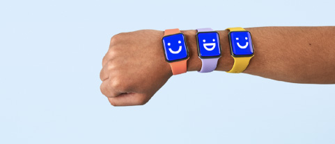 Three apple watches displaying visible emojis on one wrist