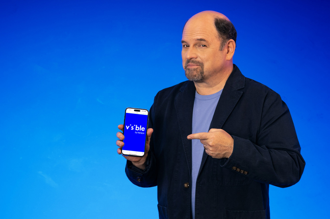 jason alexander smiling with a visible phone