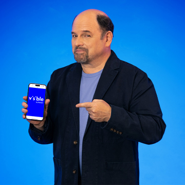 jason alexander smiling with a visible phone