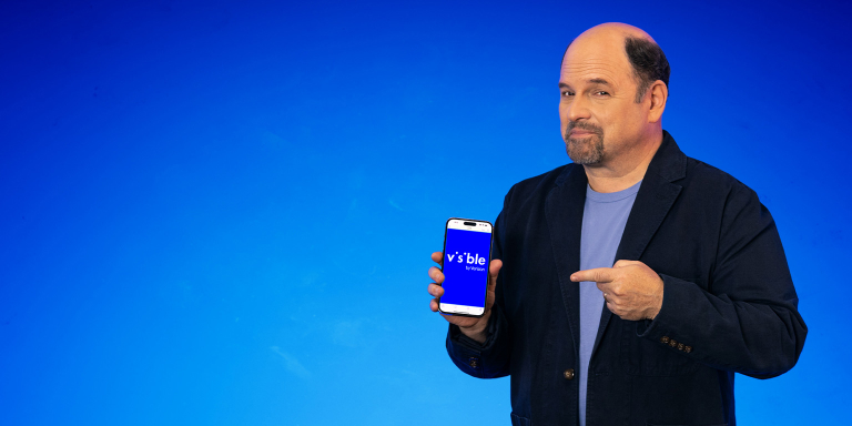 jason alexander smiling with a visible phone